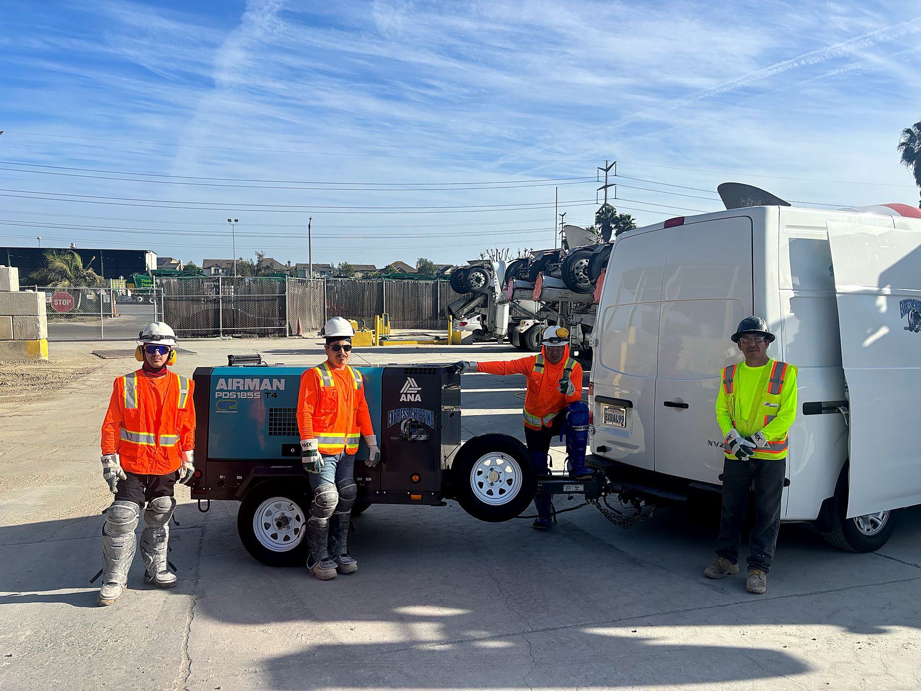 Express Chipping crew in hard hats and high visibility gear with an Airman compressor and branded service van at a ready mix plant