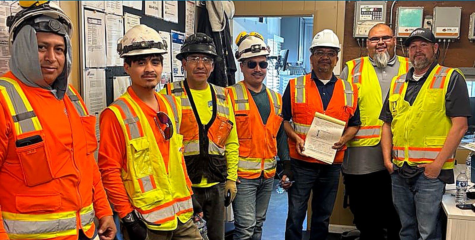 Express Chipping concrete chipping crew in hard hats and high visibility vests at an OSHA safety training session inside a plant office